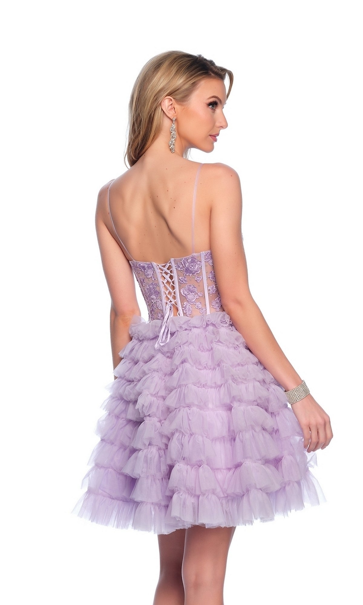 A woman in the Dave and Johnny Ruffled Purple Hoco Dress 11766, featuring a corset bodice, delicate straps, lace-up back, and ruffled skirt, stands facing away against a plain white background.